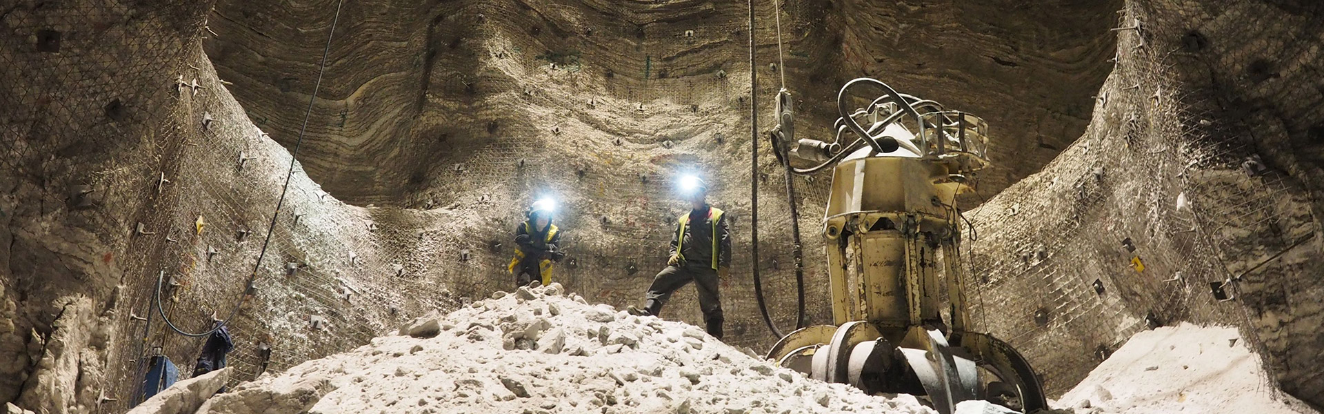 The website banner for the Cookies Policy page shows two Redpath employees standing on top a mound of rubble near heavy duty machinery, deep inside an excavated mine.