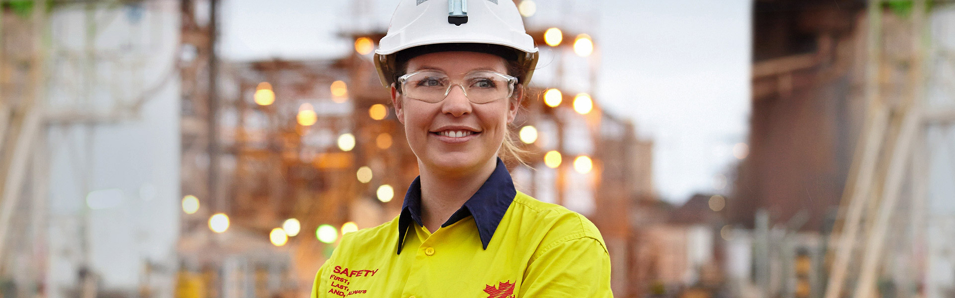 The website banner for the Copyright page shows a young female Redpath employee standing in front of a work site, wearing safety goggles and a hard hat, smiling and looking optimistically out into the distance.