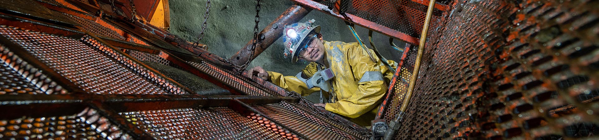 The website banner for the Mechanized Raise Mining page shows a male Redpath employee operating a mechanized raise climber, showing intimate knowledge of its performance and maintenance specifications.