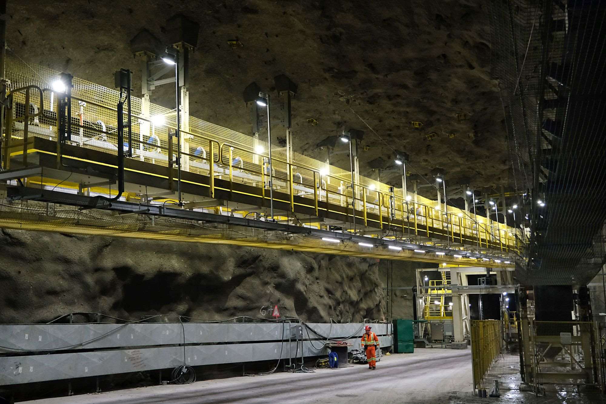 Conveyor belt at Voisey's Bay with IIR worker walking below it